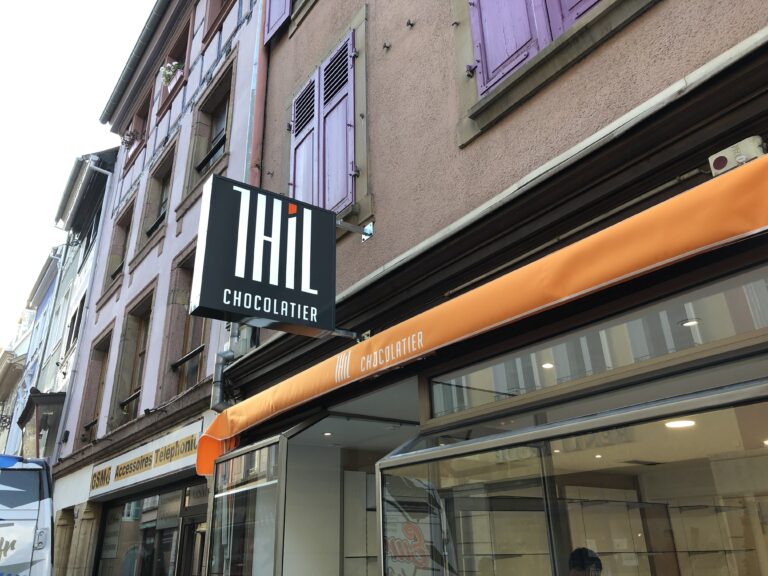 Une enseigne caisson drapeau sur mât Thill posée par Next dans les Vosges.