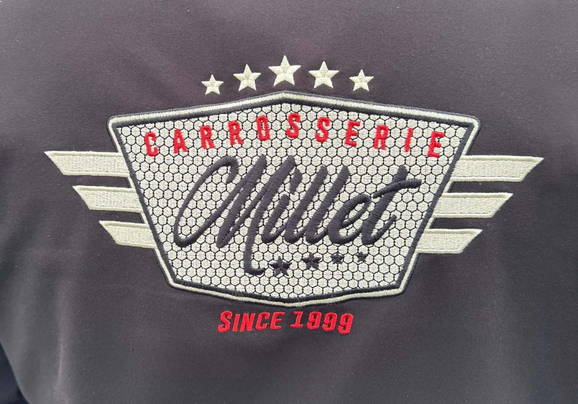 Broderie logo personnalisé Carrosserie Millet sur vêtement professionnel, réalisation Agence Next
